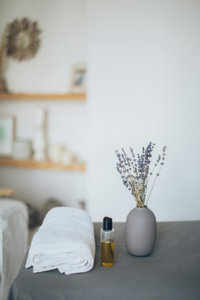 A Lavender Near the Bottle with Oil and a Bath Towel